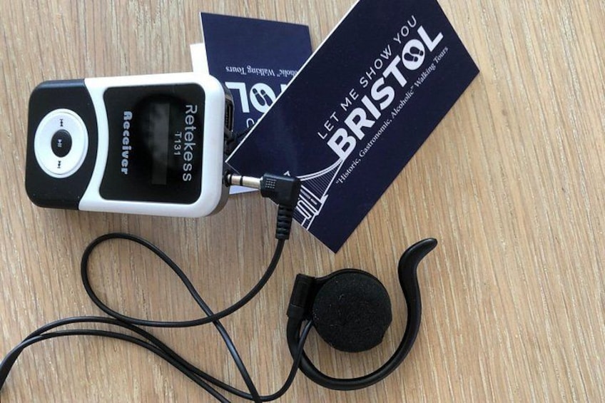 A device labeled 'Retekess' with a cable and a black earphone, connected to a card with 'LET ME SHOW YOU BRISTOL' text. 4