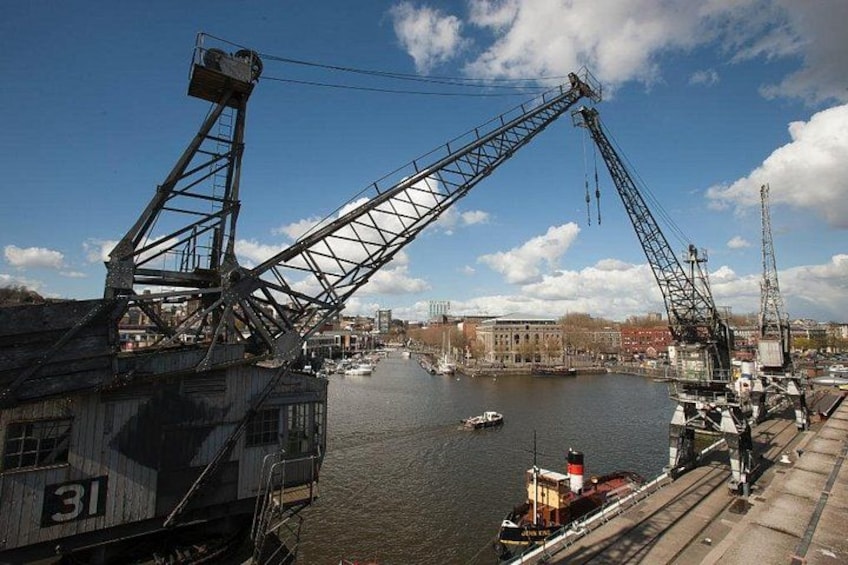 A harbor with cranes and a ship docked. 2