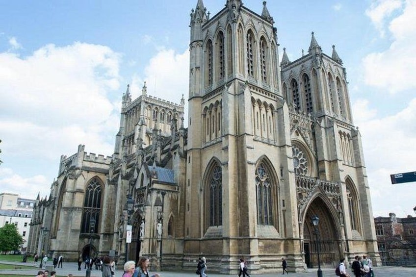 A large, historic cathedral with intricate architecture and a crowd of people in front. 1