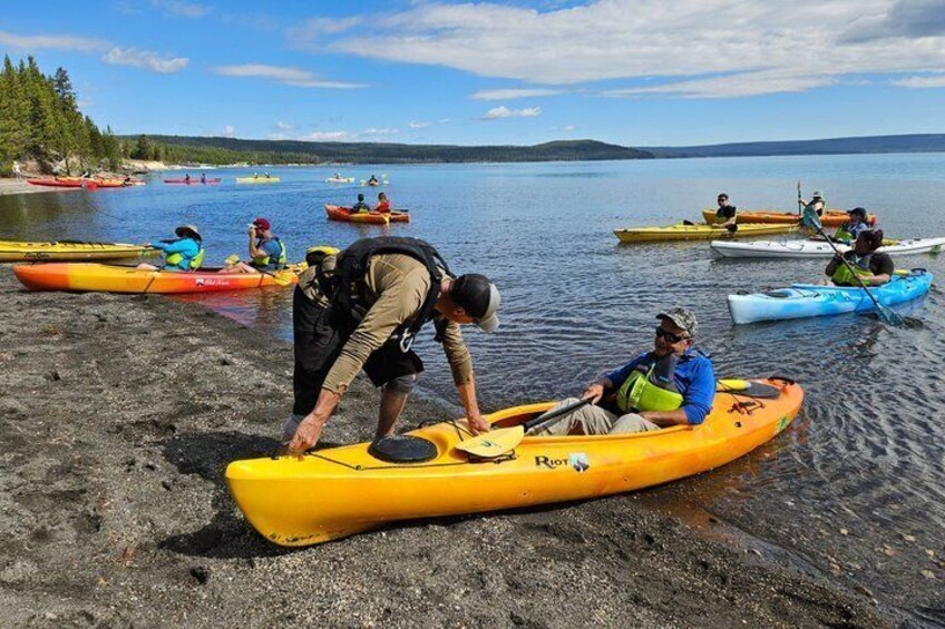 People kayaking on a calm lake with clear skies. 2