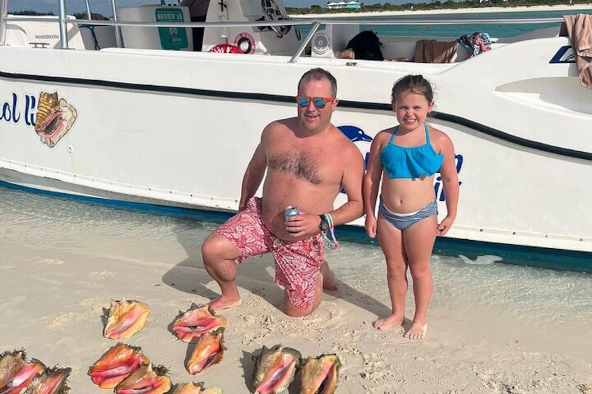 Un hombre y una mujer en la playa, con un bote al fondo. 2
