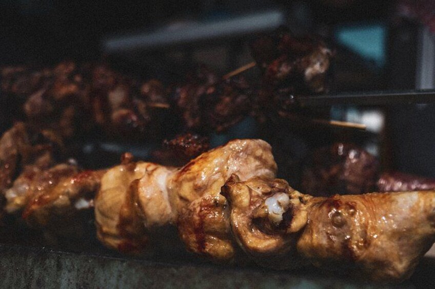 A close-up of a meat skewer with visible marbling and a charred exterior, suggesting it has been grilled or barbecued. 1