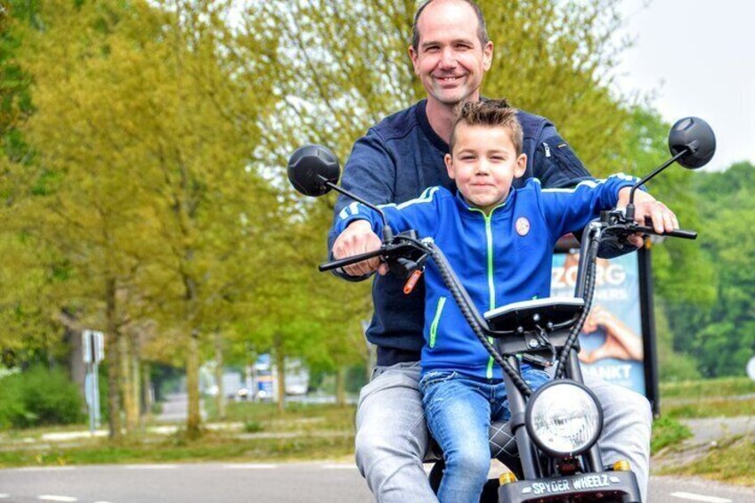 A man and a child on a scooter. 2