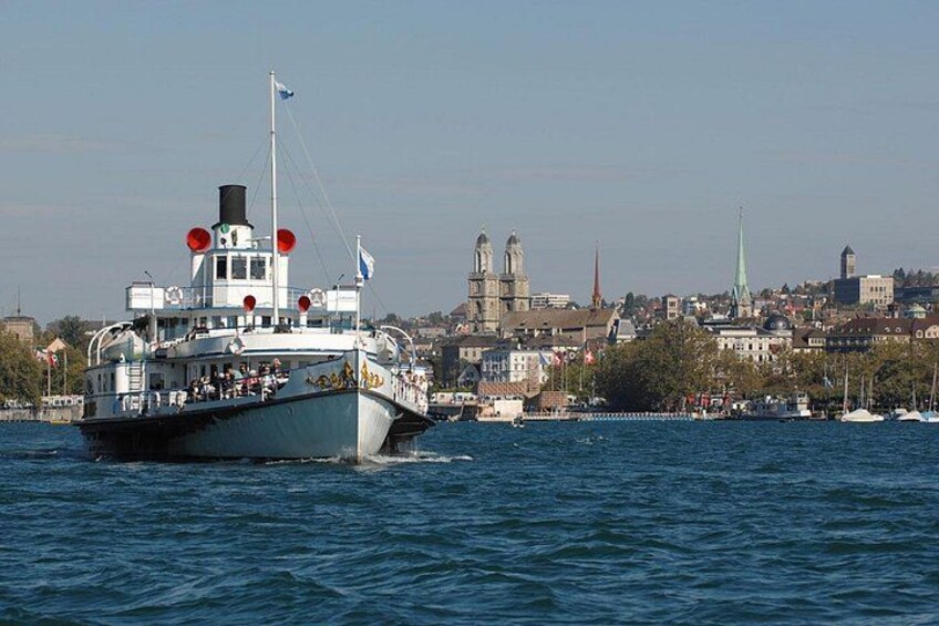 Een boot op het water, met een stadsgezicht op de achtergrond. 3