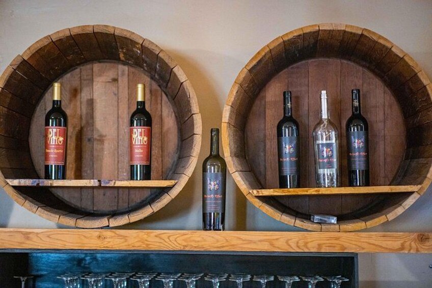 Deux tonneaux en bois contenant des bouteilles de vin, fixés à un mur. 2