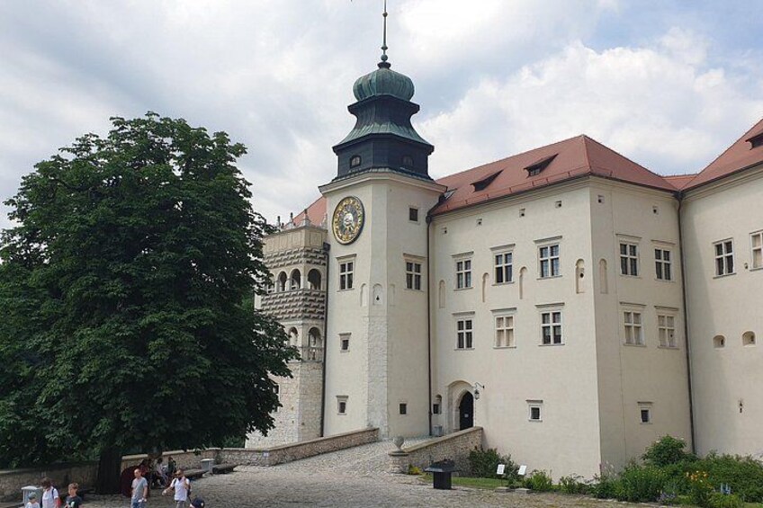 A historic building with a clock tower, large windows, and a red roof. 3