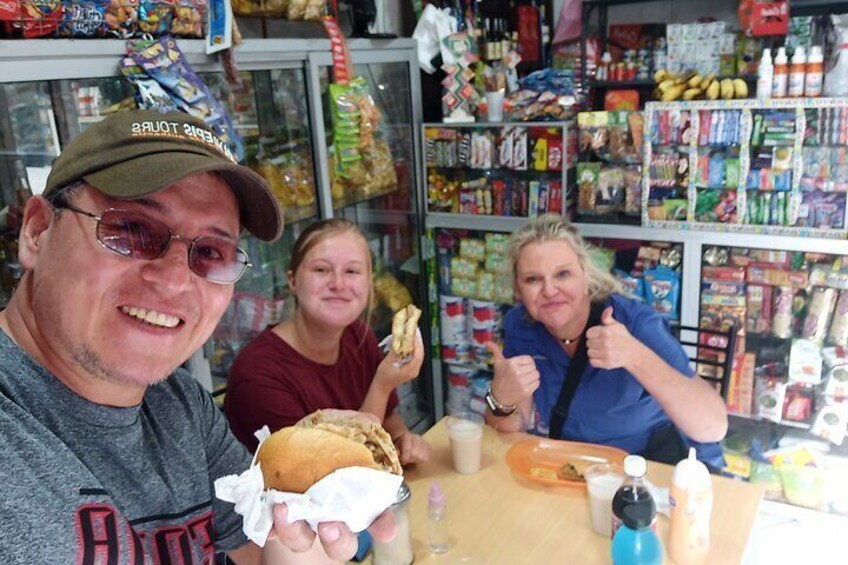 Trois personnes sont assises à une table dans un magasin et tiennent des produits alimentaires. 1