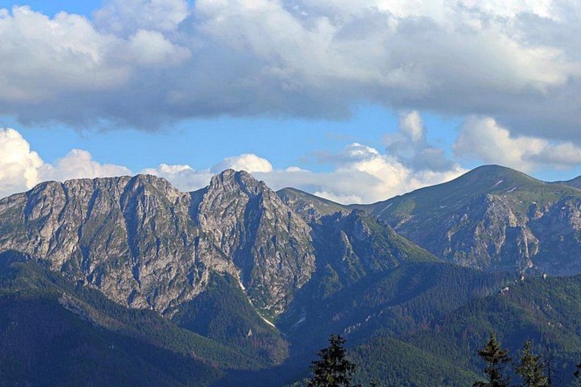 Una cordillera con picos escarpados y valles densamente boscosos. 2