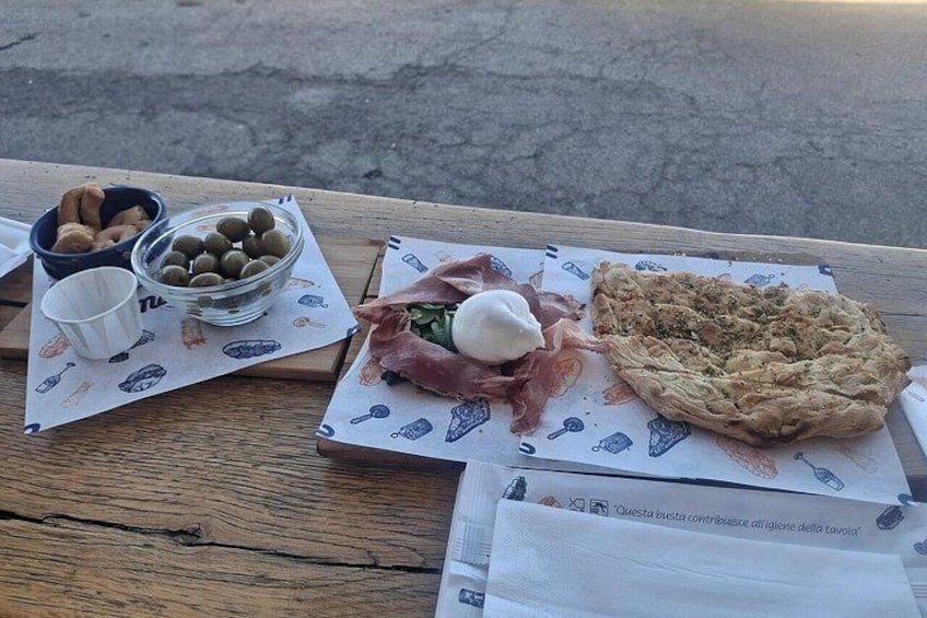 Una mesa de madera con una comida que incluye aceitunas, un pastel y carne curada. 3