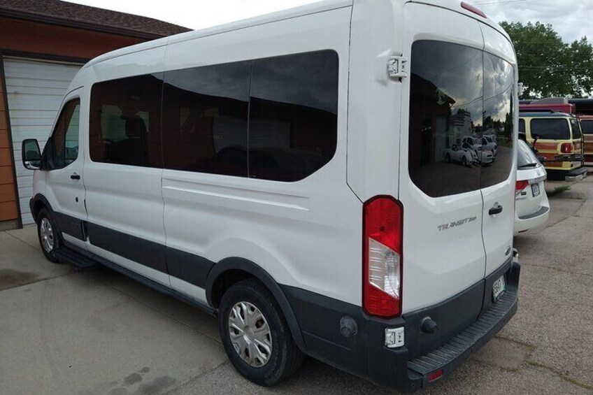 A white van parked in front of a building with a garage door. 4