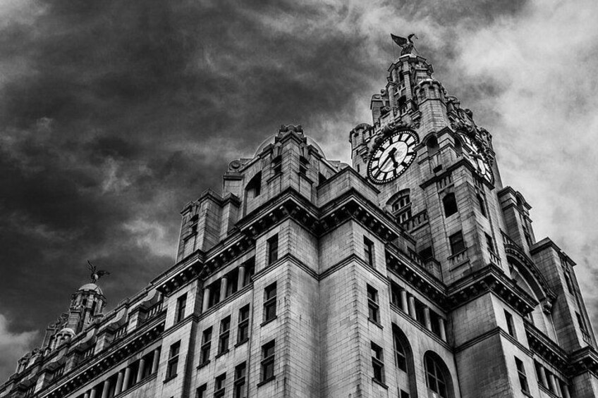 A historic building with a clock tower, ornate architecture, and a statue on top. 4