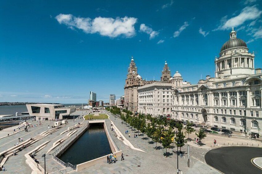 A waterfront cityscape with a large classical building, a modern structure, and a canal. 2