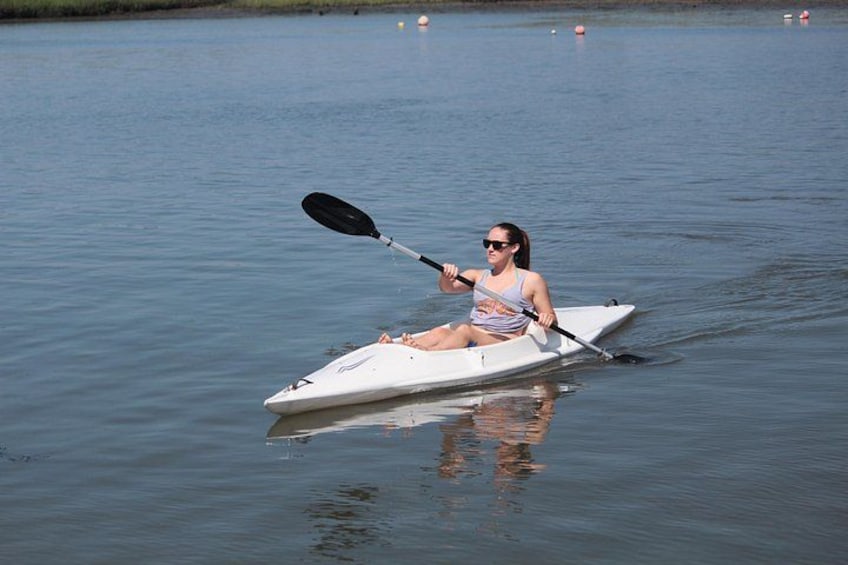 A person kayaking on a calm body of water. 2
