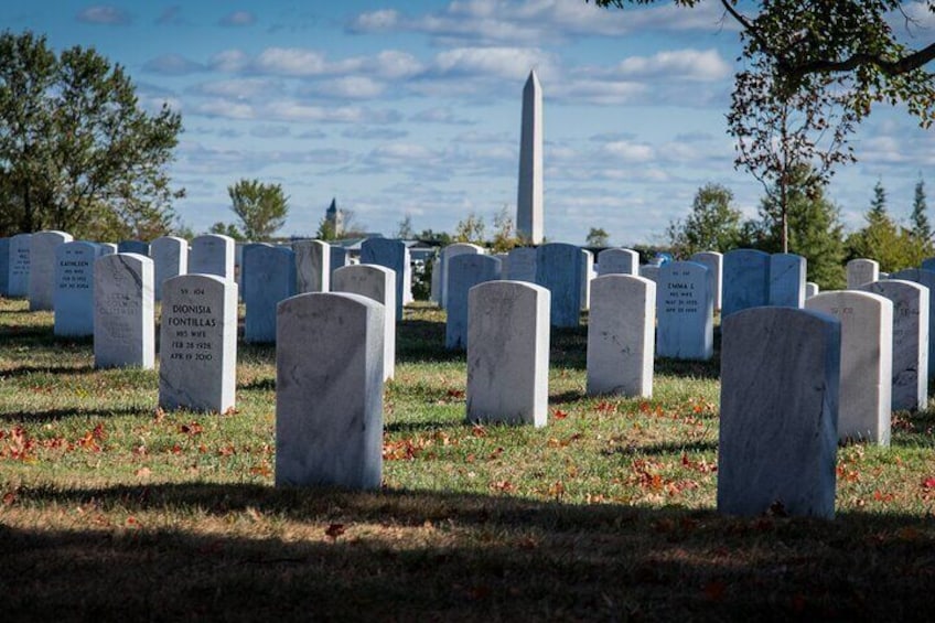 A cemetery with headstones and a monument in the background. 5