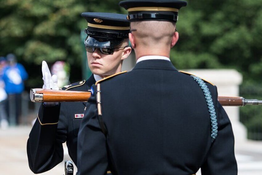 Two uniformed individuals in ceremonial attire, one holding a ceremonial rifle. 4