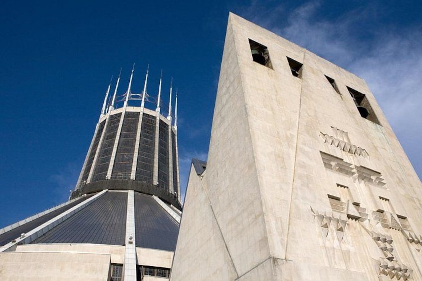 A modern building with a unique architectural design, featuring a tall tower with multiple spires and a large, angular structure with cut-out patterns. 2