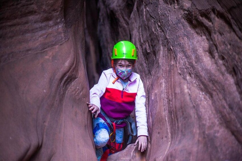 Una persona en un cañón, usando casco y arnés. 2