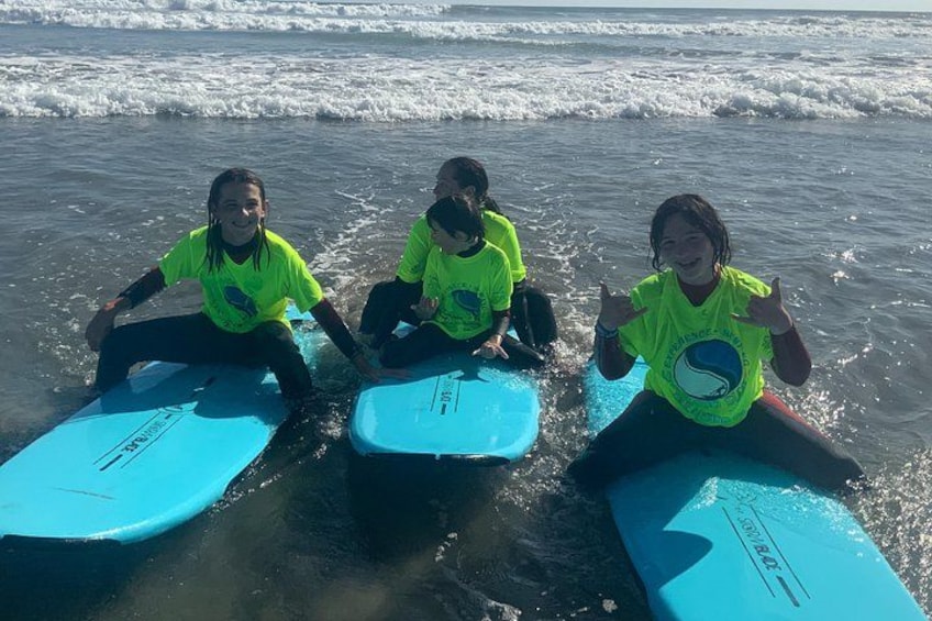 Tre persone sedute sulle tavole da surf in spiaggia. 5