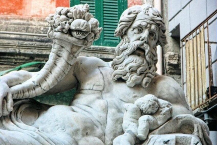 A marble statue of a bearded figure with a snake. 4