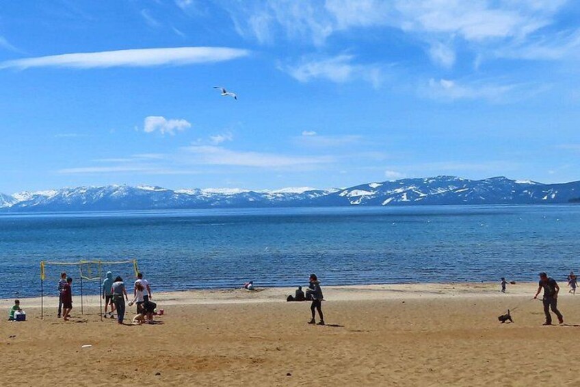 Une plage avec des gens, un but de football et des montagnes en arrière-plan. 4
