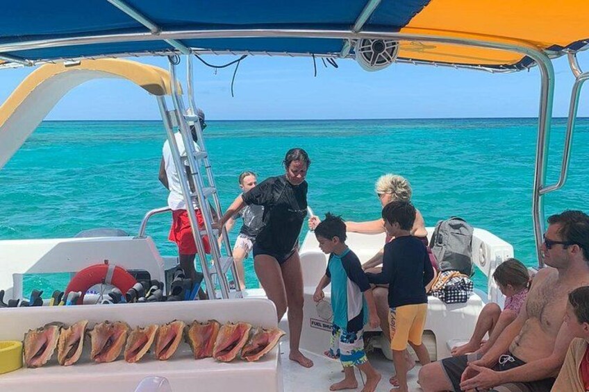 Un bateau avec des personnes à bord, une échelle et une rangée de coquillages. 4