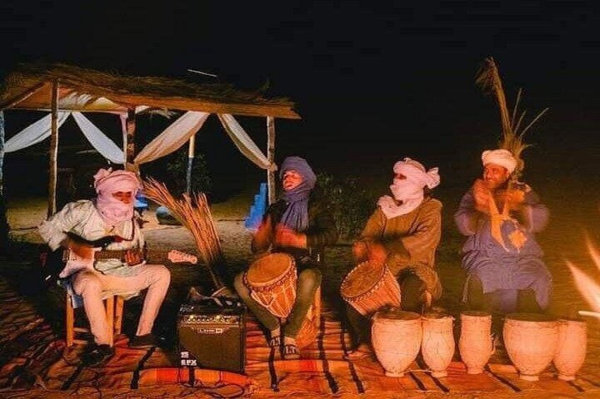 Un grupo de personas tocando la batería al aire libre de noche. 3