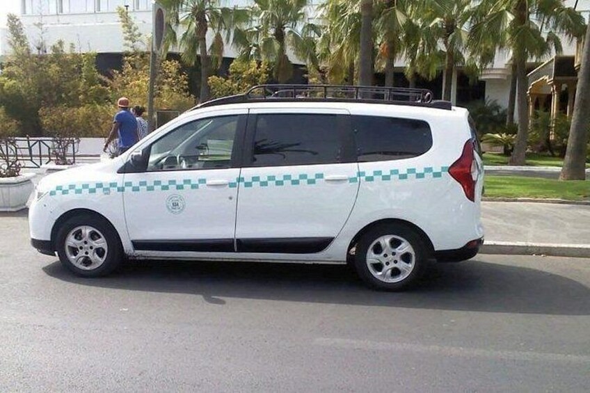 A white van with a checkered pattern parked on a street. 2