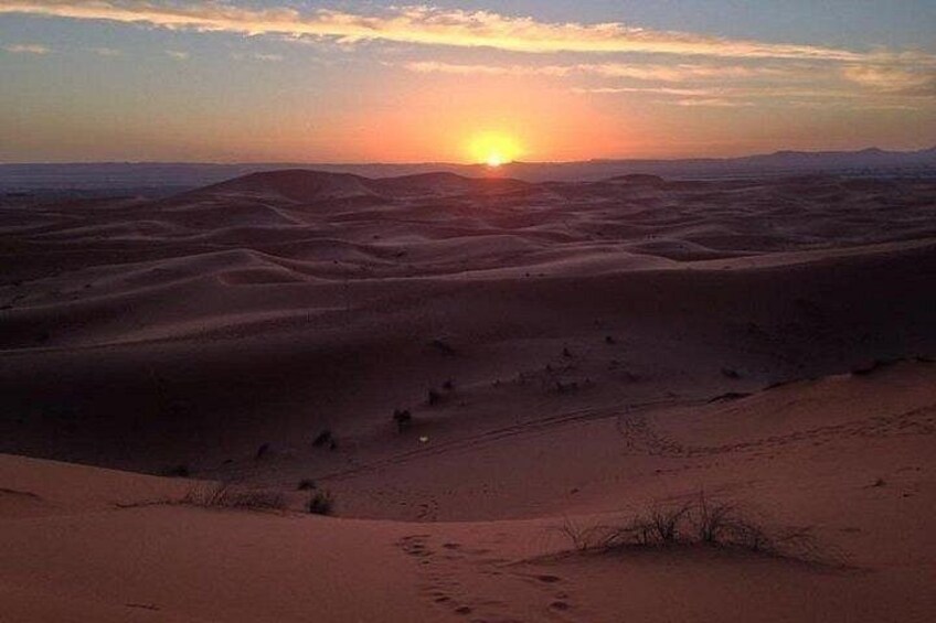 A desert landscape with sand dunes and a sunset. 4