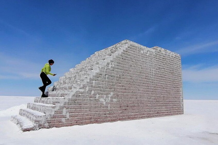 Una persona escalando una gran estructura de ladrillo cubierta de nieve. 2