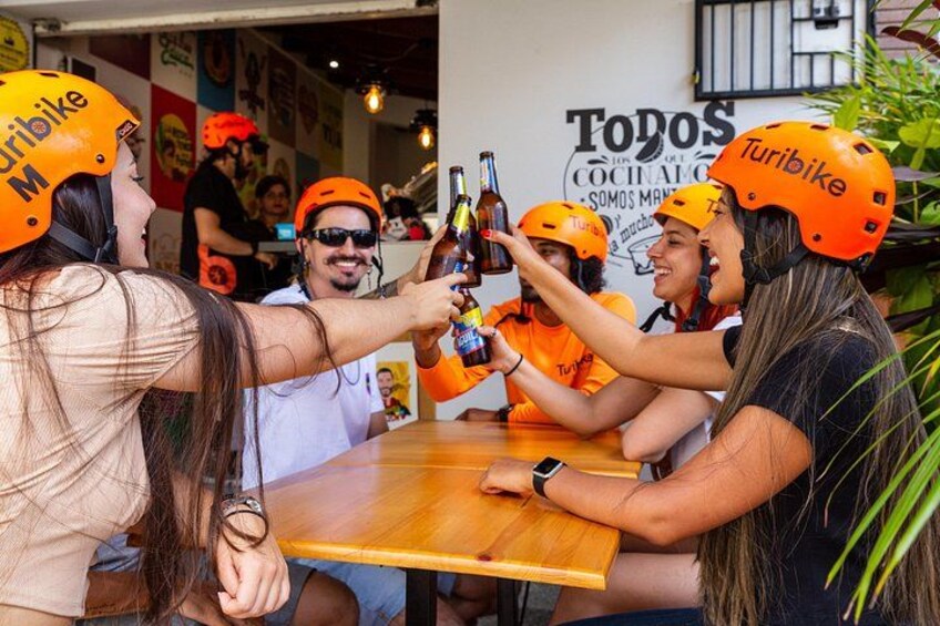 A group of people wearing orange helmets and orange shirts, toasting with bottles. 4