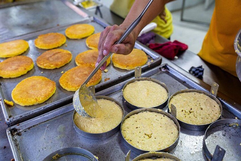 A person cooking pancakes on a griddle. 3