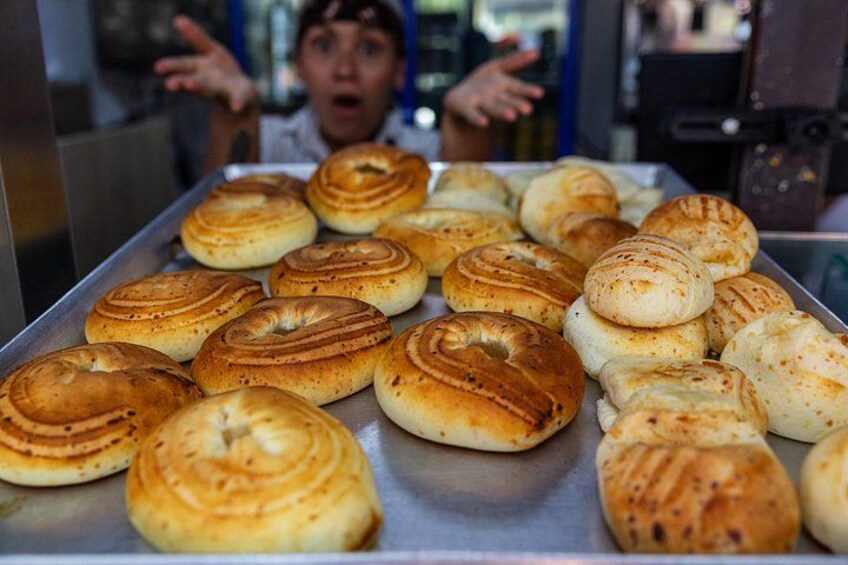 A tray of freshly baked bagels with a variety of toppings. 2