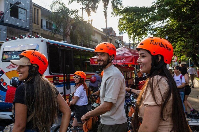 People wearing helmets with the word 'Turibike' on them, standing near a bus. 5