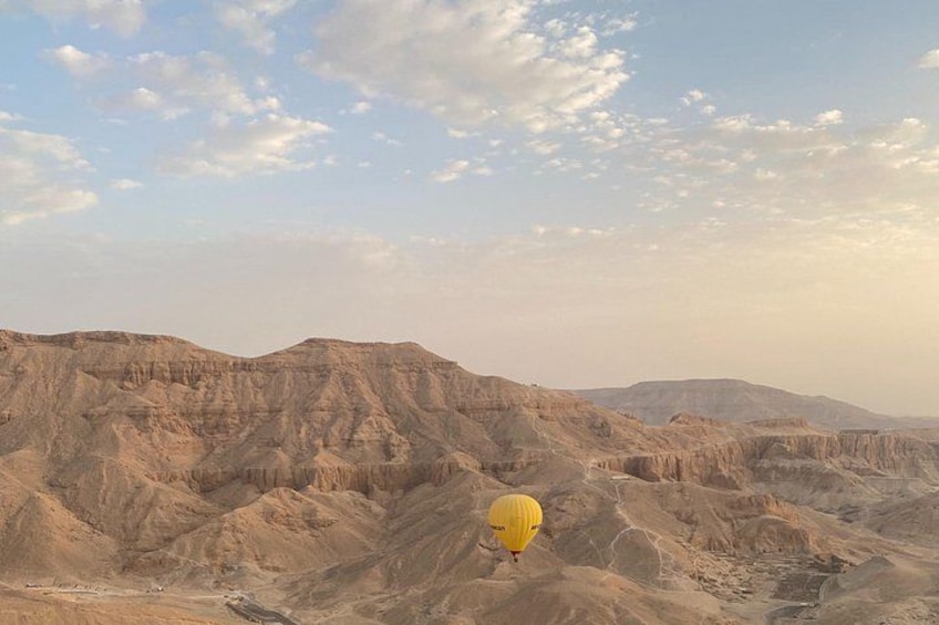 Un paysage désertique avec, au loin, un ballon à air chaud jaune. 2