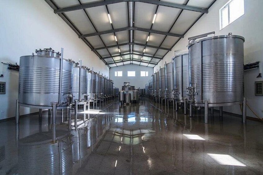 A clean, industrial interior with stainless steel tanks and a polished floor. 4