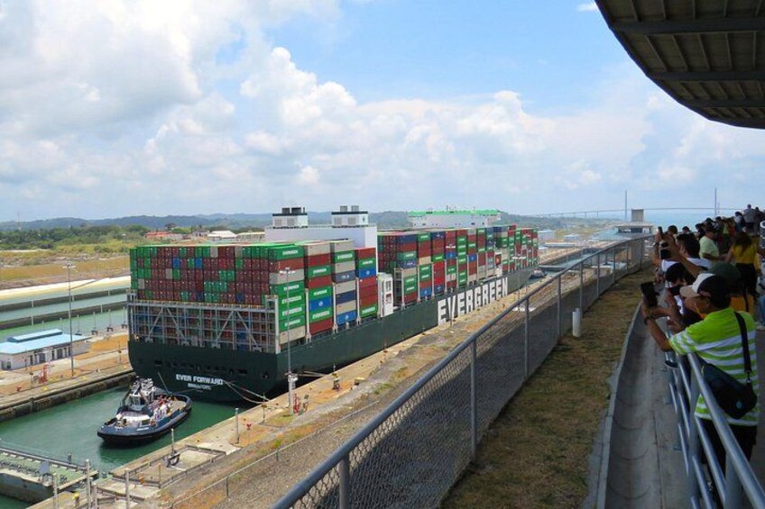 A large cargo ship named 'Evergreen' docked at a port with a tugboat nearby. 5