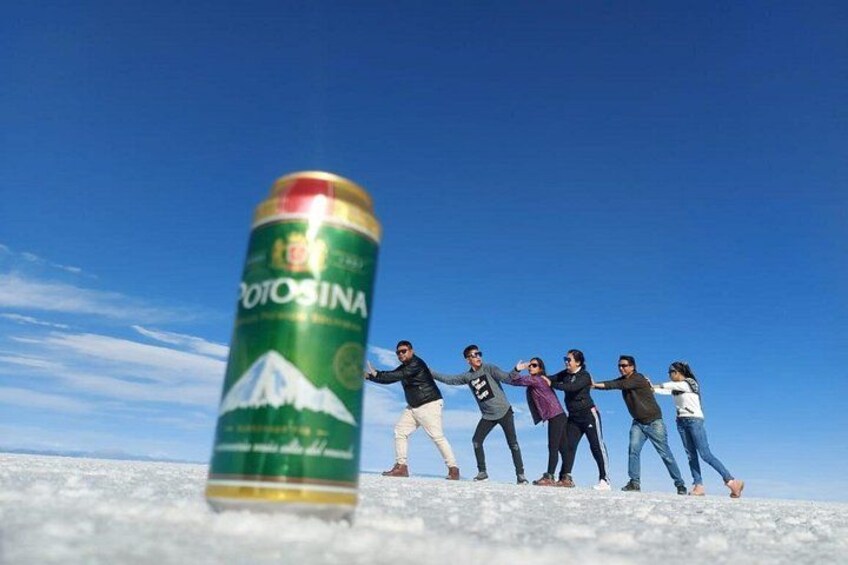 Un grupo de personas sobre una superficie plana, con una lata de bebida al frente. 5