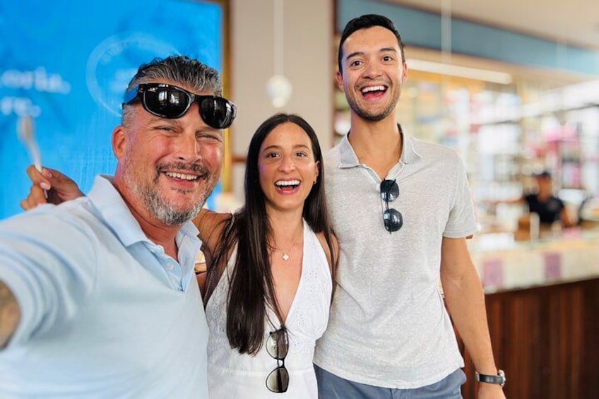 Three people taking a selfie in a store with a blue sign in the background. 4