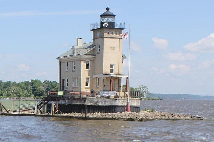 Un phare perché sur un promontoire rocheux, offrant une vue dégagée sur l’eau et un pont situé au loin. 5