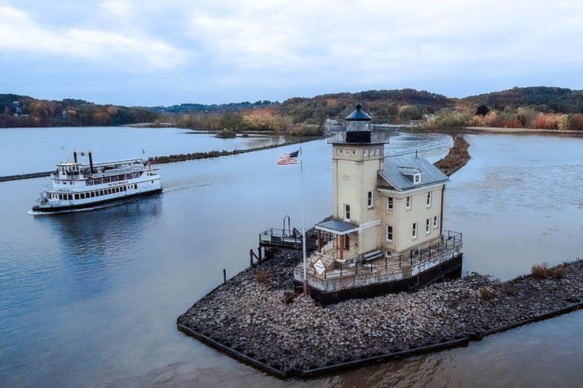 A river with a white boat, a lighthouse on a small island, and a dock. 3