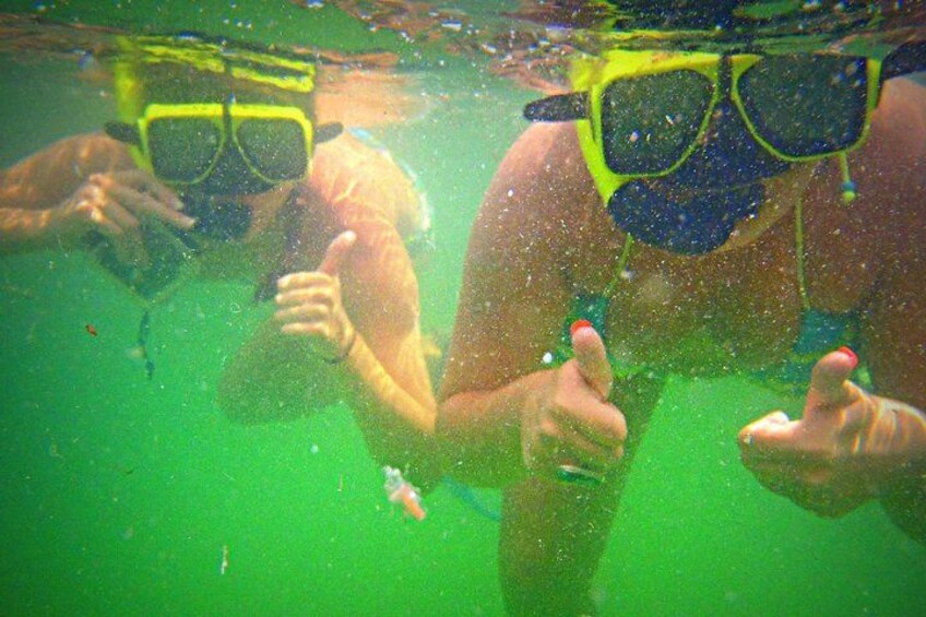 Two people underwater, wearing snorkels and giving thumbs up. 2