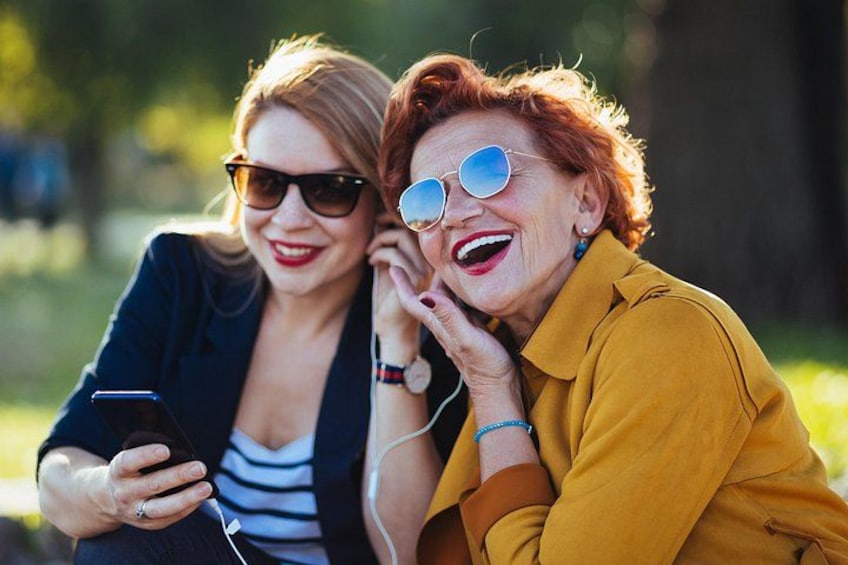 Zwei Personen draußen sitzen, eine hält ein Smartphone. 5