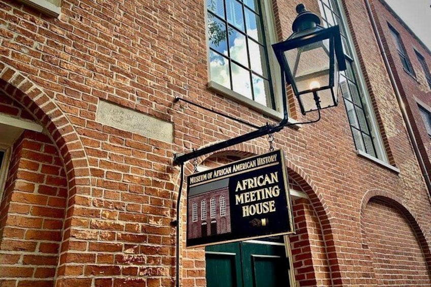 A brick building with a sign for the African Meeting House. 3