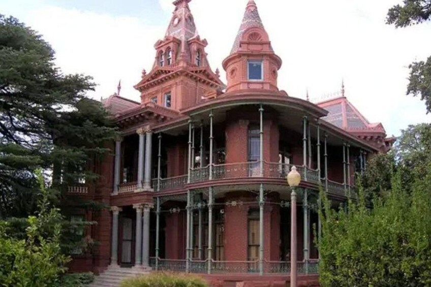 A large, ornate Victorian-style house with a prominent turret and balcony. 1