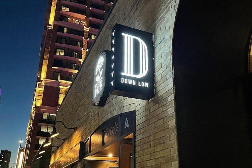 A building with illuminated signs, including one that reads 'DOWN LOW.' 2
