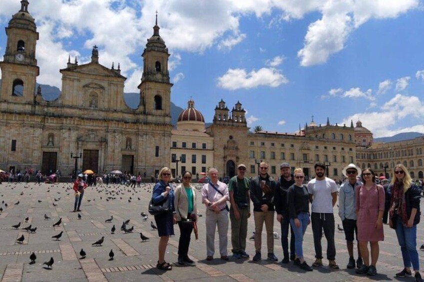 A group of people standing in front of a historic building with two bell towers and a dome. 4