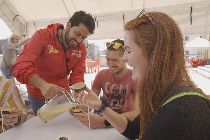 People at a table with a person pouring a drink into a glass. 3