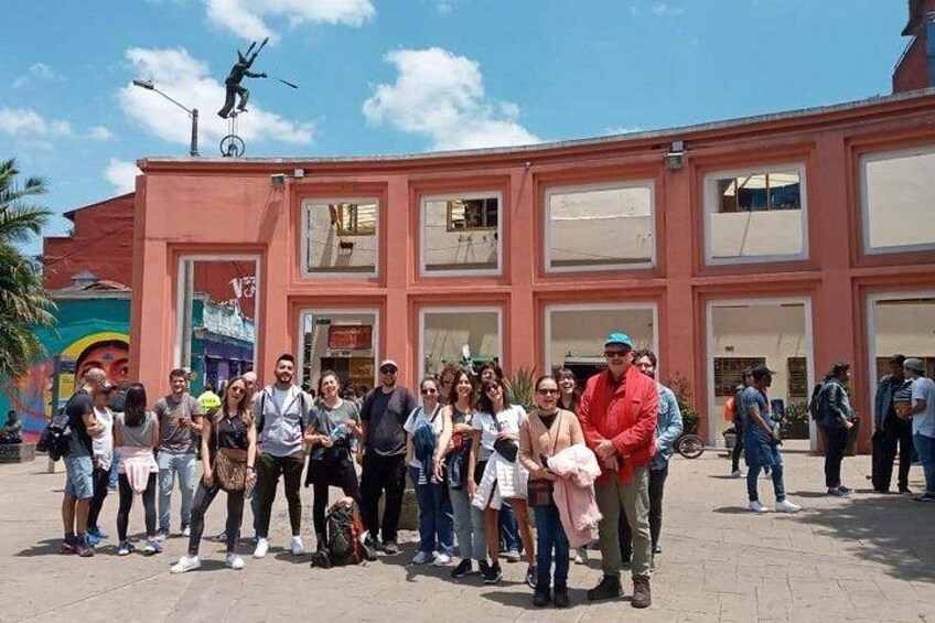 A group of people standing in front of a building with a statue on top. 2