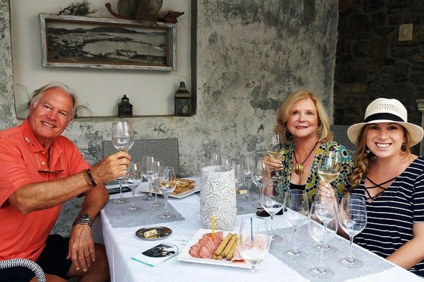 A group of people sitting at a table with wine glasses, plates of food, and a candle. 3