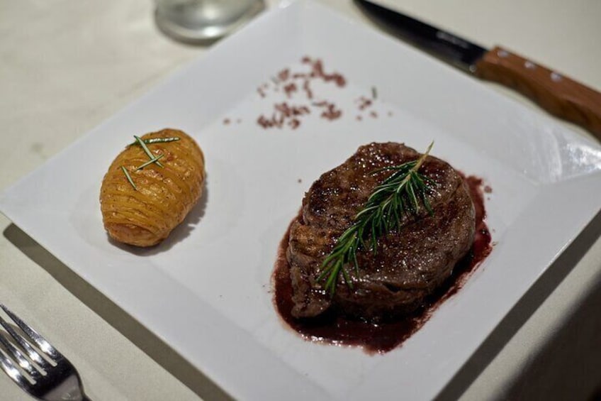 A plate with a steak and a pastry. 1